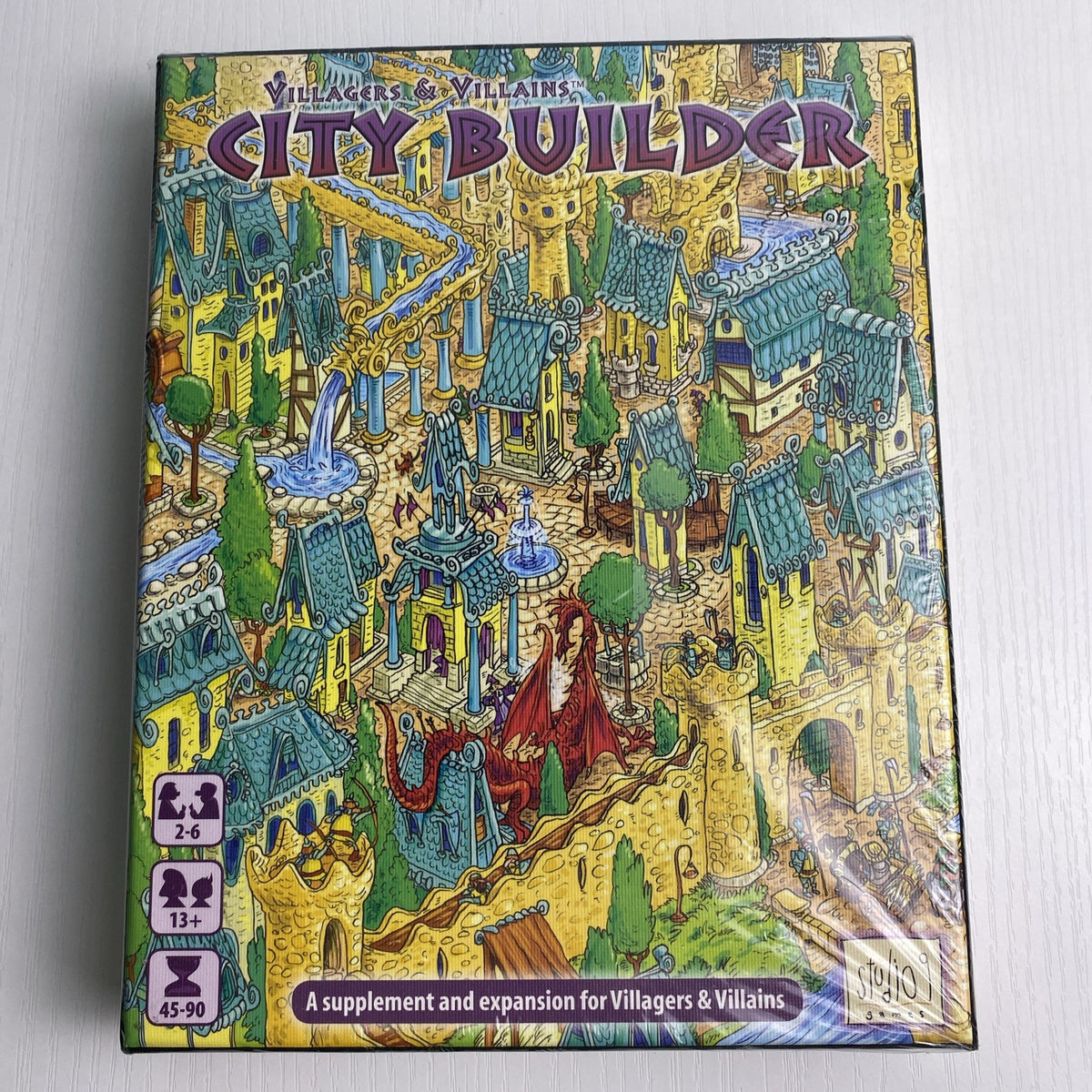 Studio 9 Games Villagers & Villains City Builder tabletop game expansion box in protective wrap