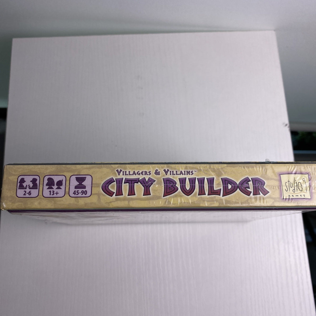 Studio 9 Games Villagers & Villains City Builder tabletop game expansion box in protective wrap
