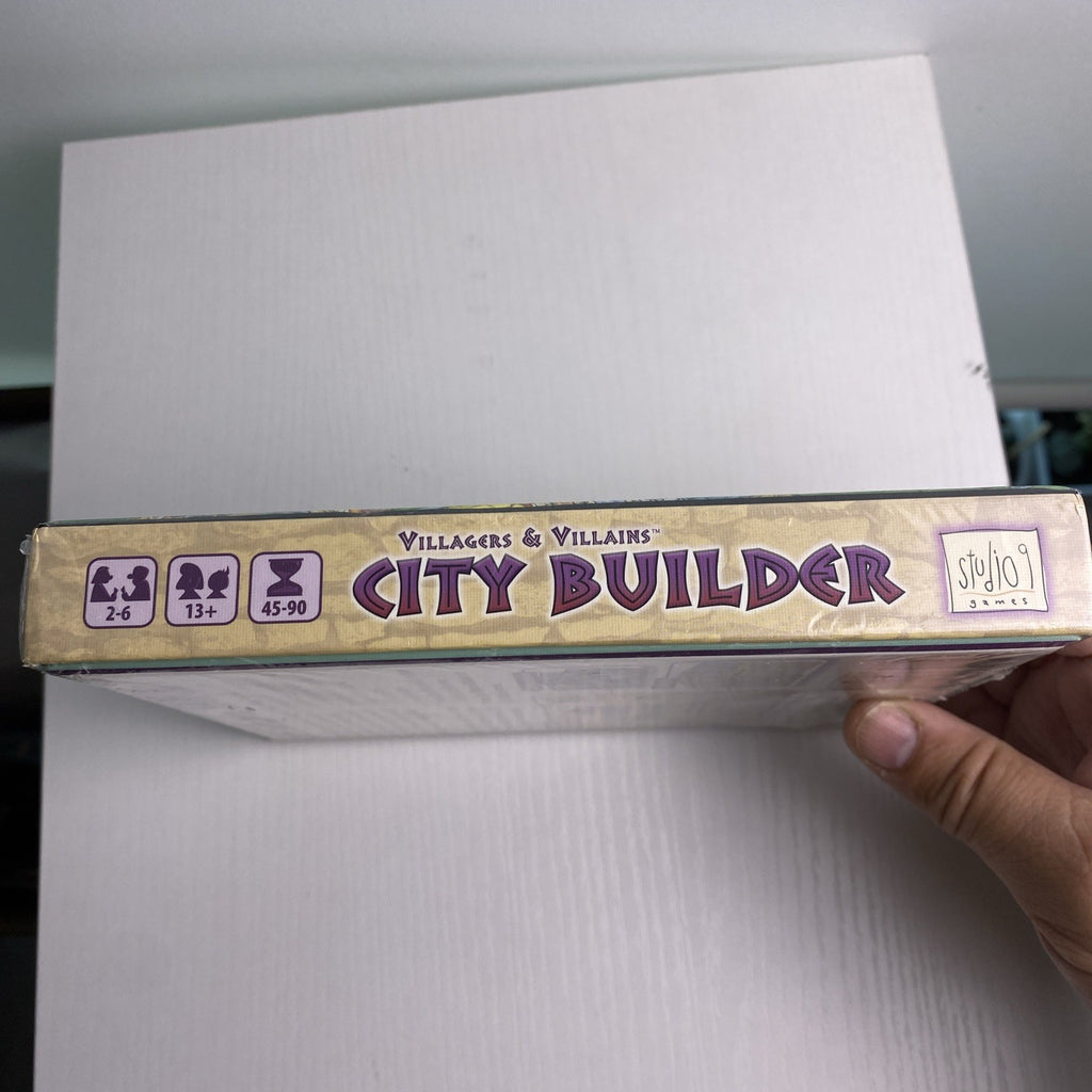 Studio 9 Games Villagers & Villains City Builder tabletop game expansion box in protective wrap