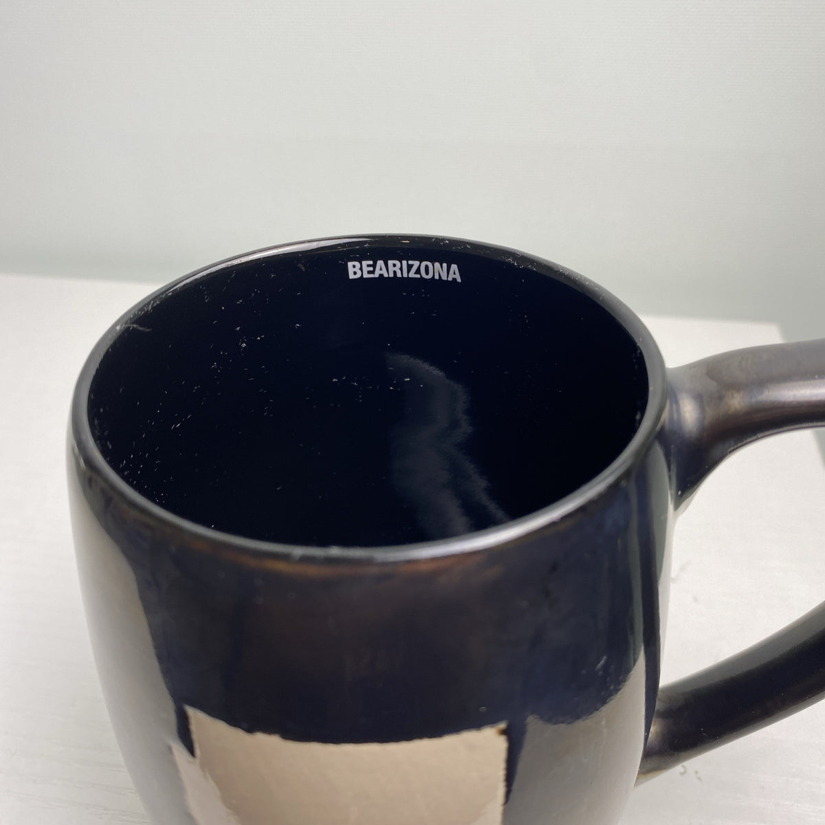 Big Sky Carvers Bearizona stoneware coffee mug with bronze metallic glaze and Arizona map