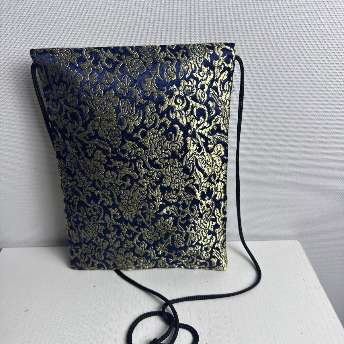 Chinese cobalt blue and gold silk brocade neck pouch featuring a Shou longevity medallion and brass bell toggle