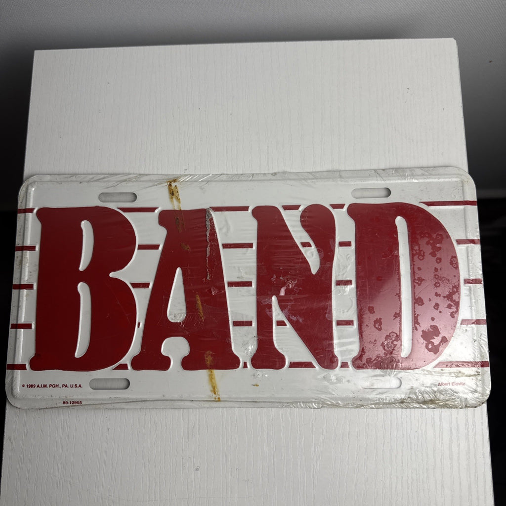 1989 Albert Elovitz embossed metal BAND music novelty license plate, 6x12 inches sealed in original plastic.