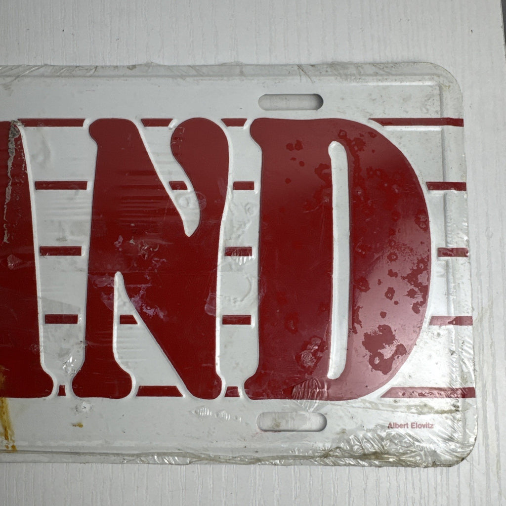 1989 Albert Elovitz embossed metal BAND music novelty license plate, 6x12 inches sealed in original plastic.