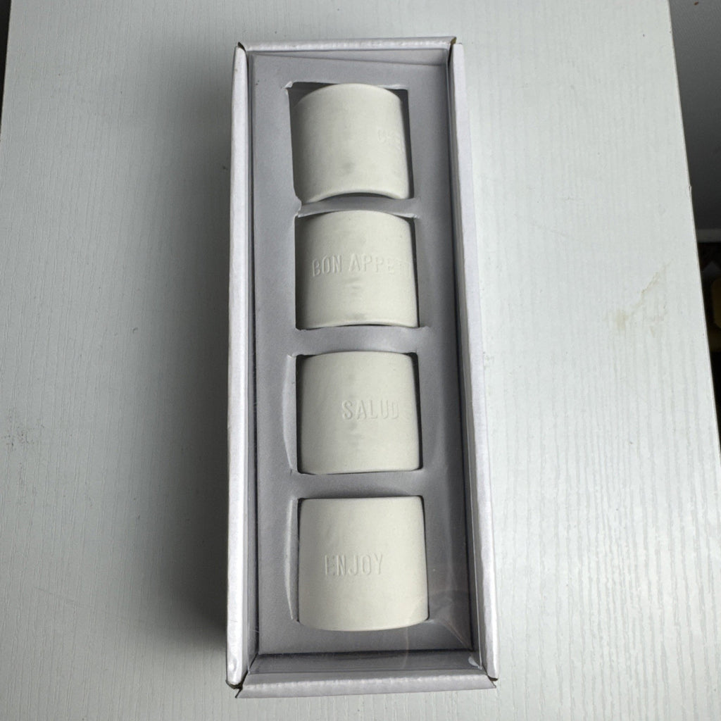 Santa Barbara Design Studio set of four white ceramic napkin rings debossed with entertaining phrases in original box