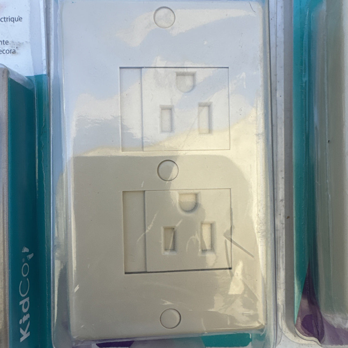 Lot of 10 packaged KidCo auto-closing safety outlet covers in beige and white for standard and Decora outlets.