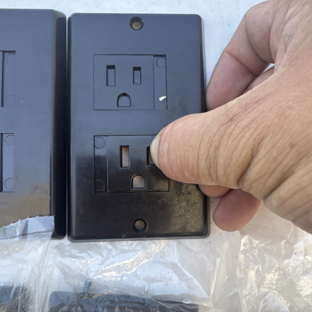 Set of 15 black and white self-closing child safety outlet cover wall plates.