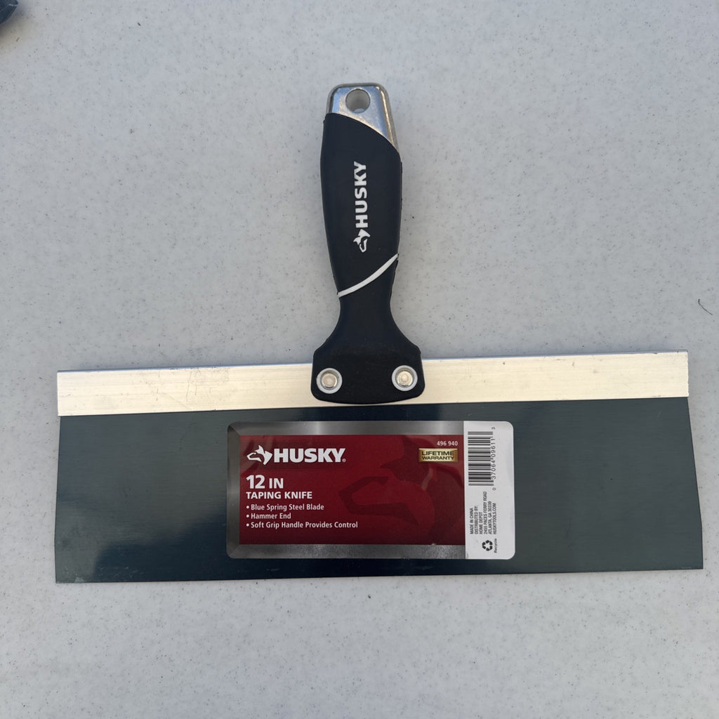 Husky 12 inch blue spring steel taping knife featuring soft grip handle and integrated hammer end