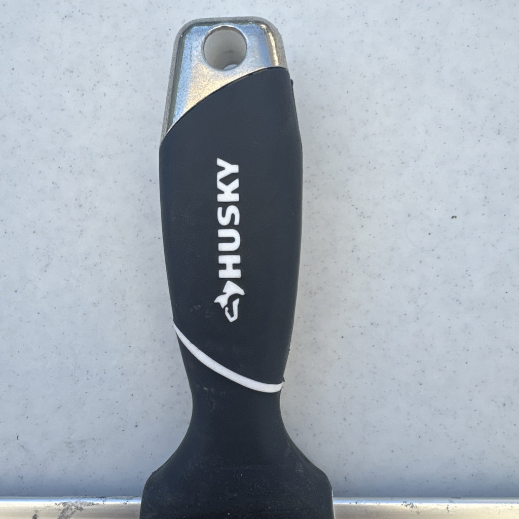 Husky 12 inch blue spring steel taping knife featuring soft grip handle and integrated hammer end
