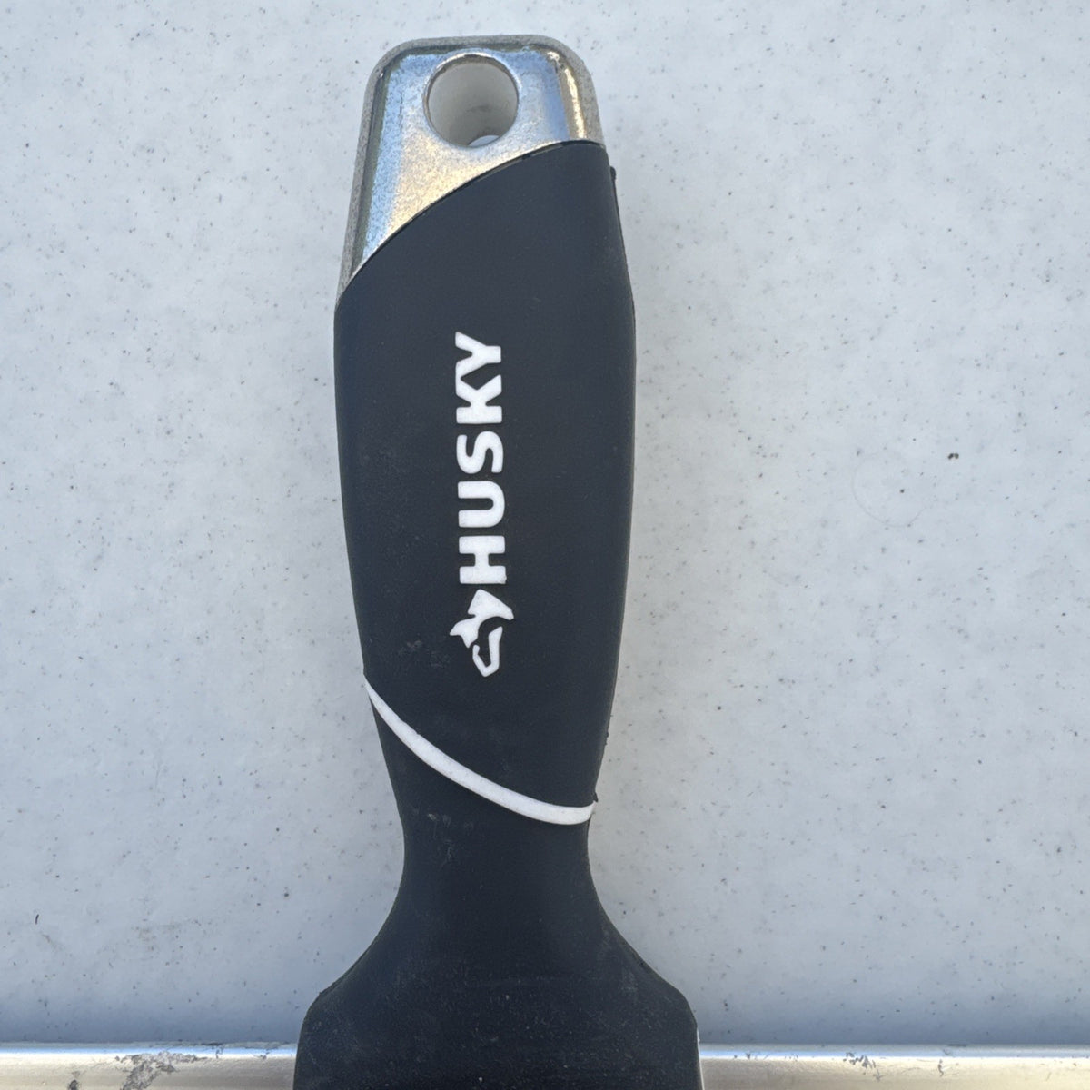 Husky 12 inch blue spring steel taping knife featuring soft grip handle and integrated hammer end