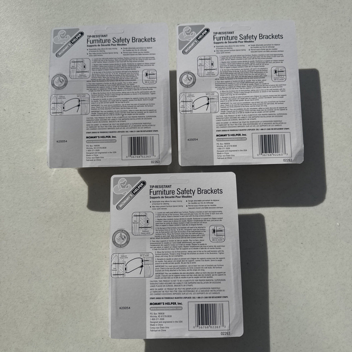 Three sealed packages of Mommy's Helper tip-resistant furniture safety brackets model 02263.
