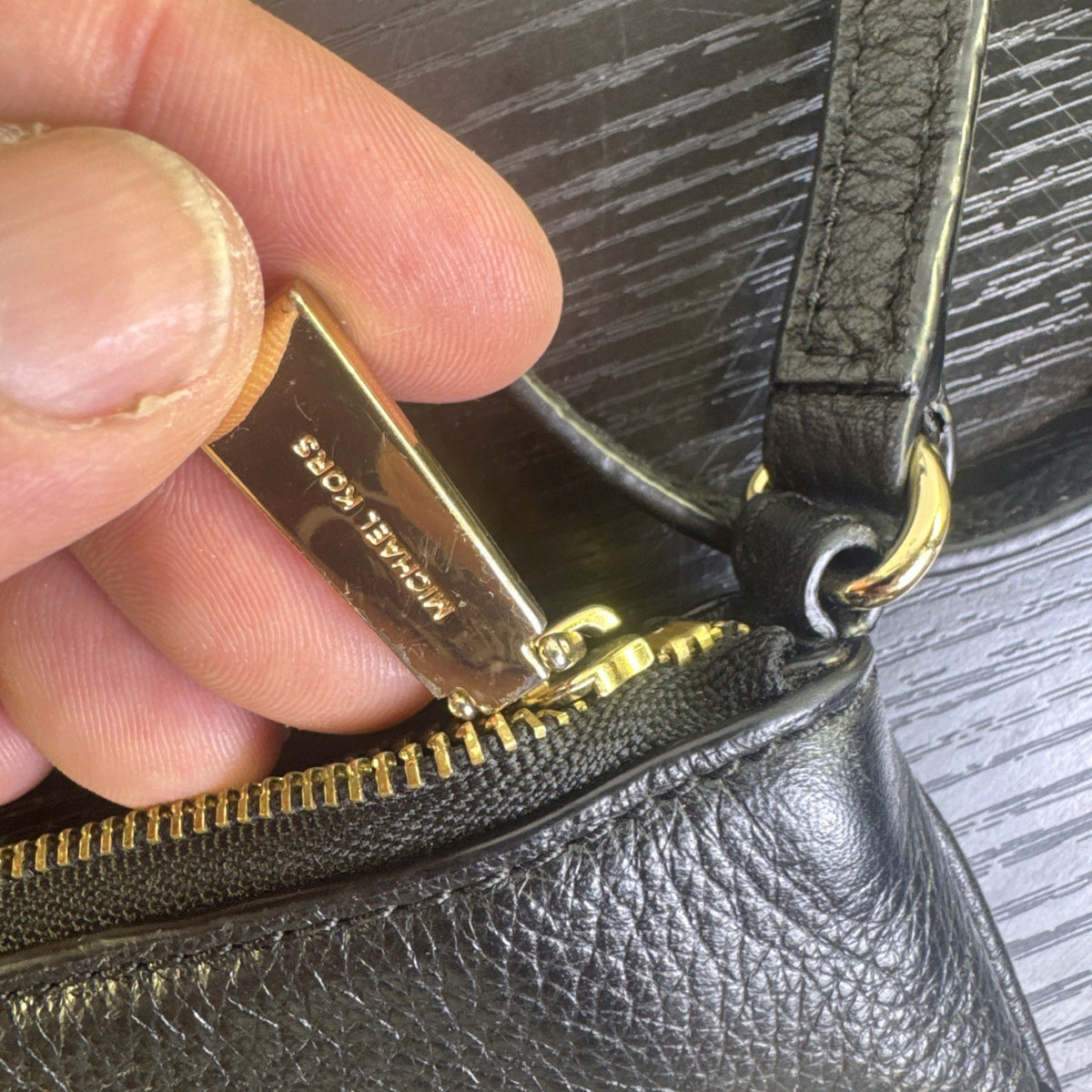 Michael Kors black pebbled leather flat crossbody bag with gold hardware and front zip pocket