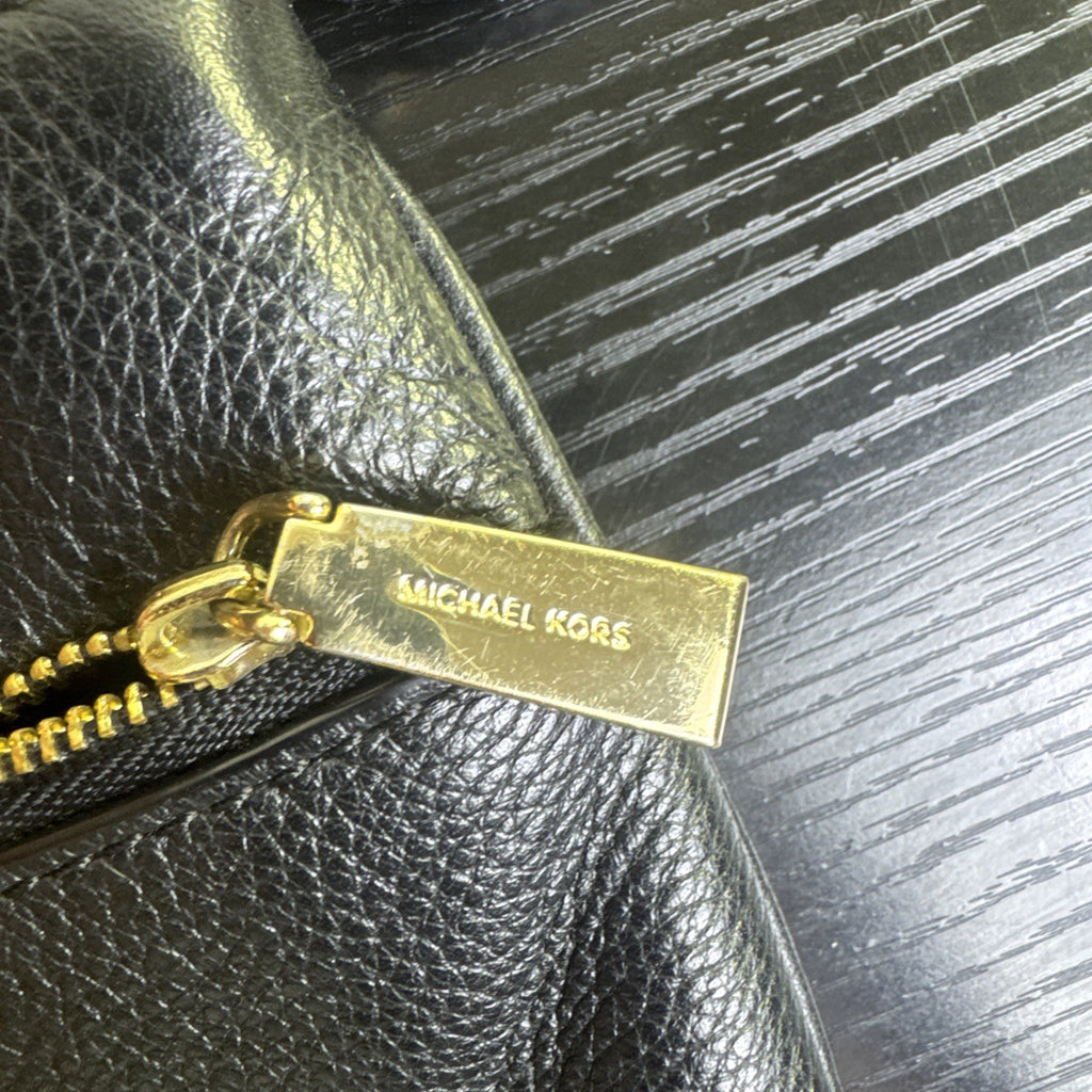 Michael Kors black pebbled leather flat crossbody bag with gold hardware and front zip pocket
