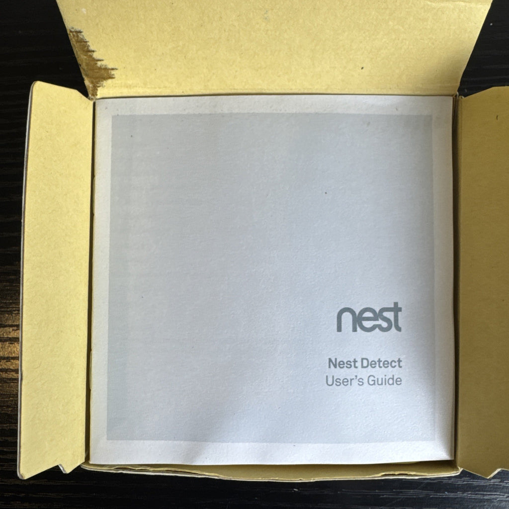 Open box Google Nest Detect H1100WES wireless door and window sensor showing its sleek white design.