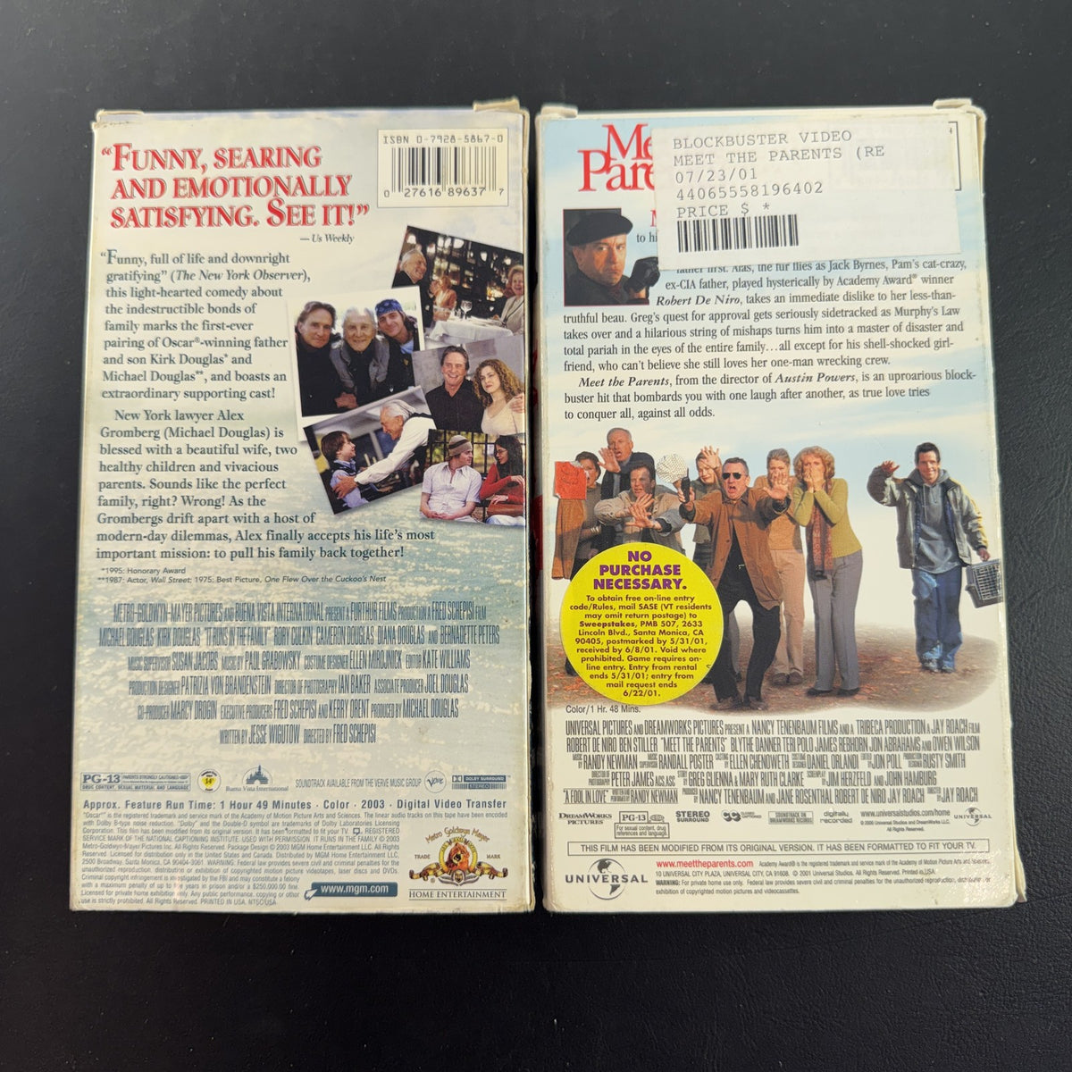 Set of two vintage comedy VHS tapes featuring Meet the Parents and It Runs in the Family in original slipcases.
