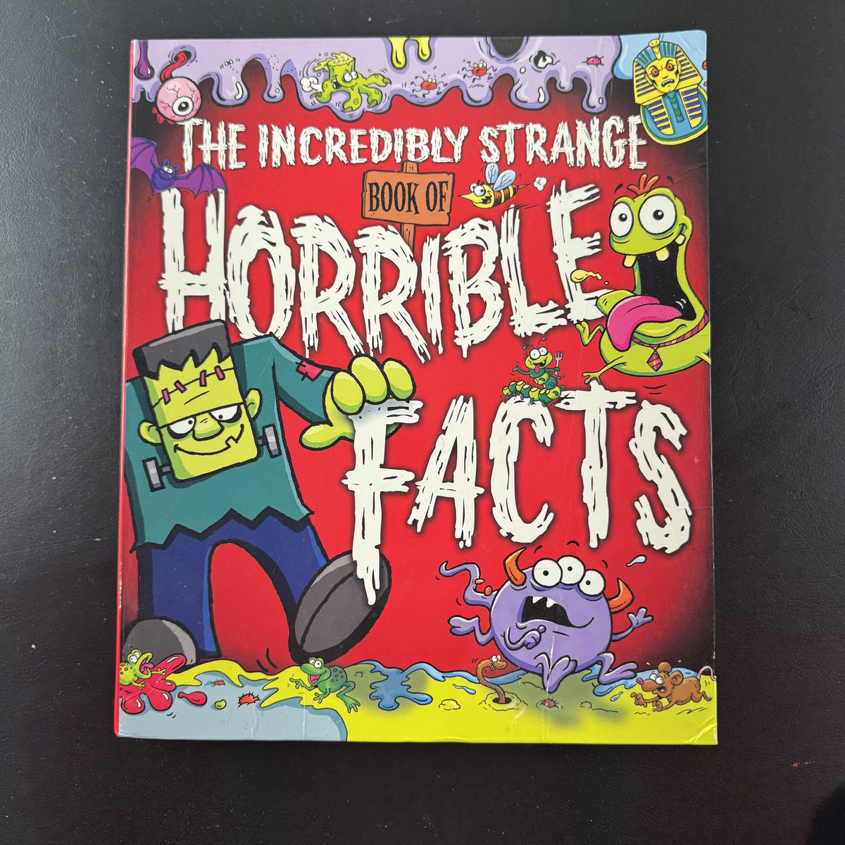 Front cover of The Incredibly Strange Book of Horrible Facts hardcover children's trivia book by Arcturus Publishing.