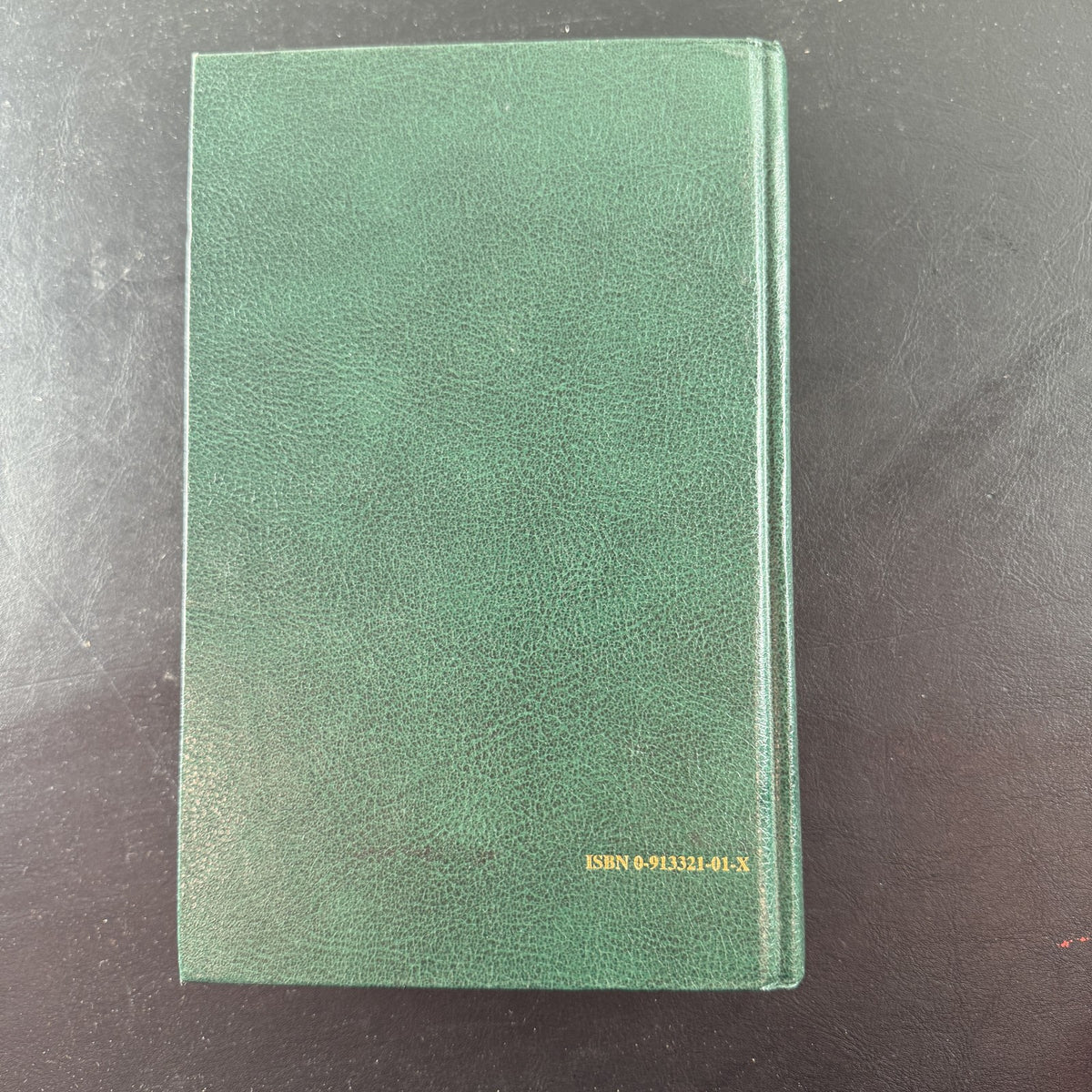 Green gold-gilt hardcover of The Holy Qur'an with English translation and commentary by Maulana Muhammad Ali.