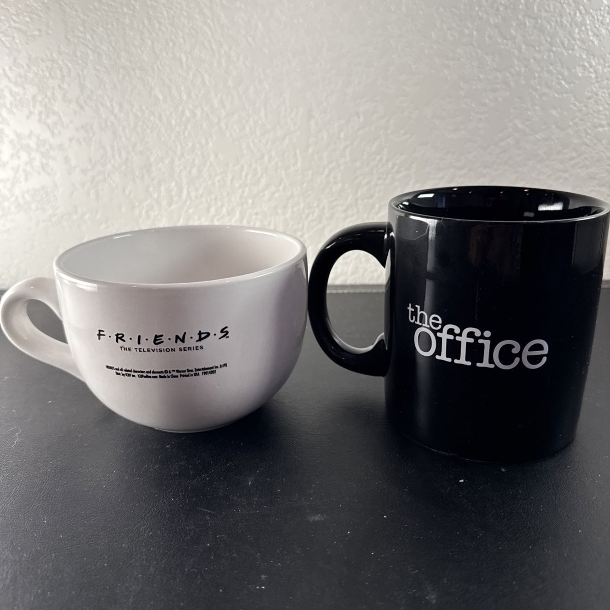 Set of 2 television show coffee mugs featuring Friends Central Perk jumbo mug and The Office Dwight Schrute black mug.