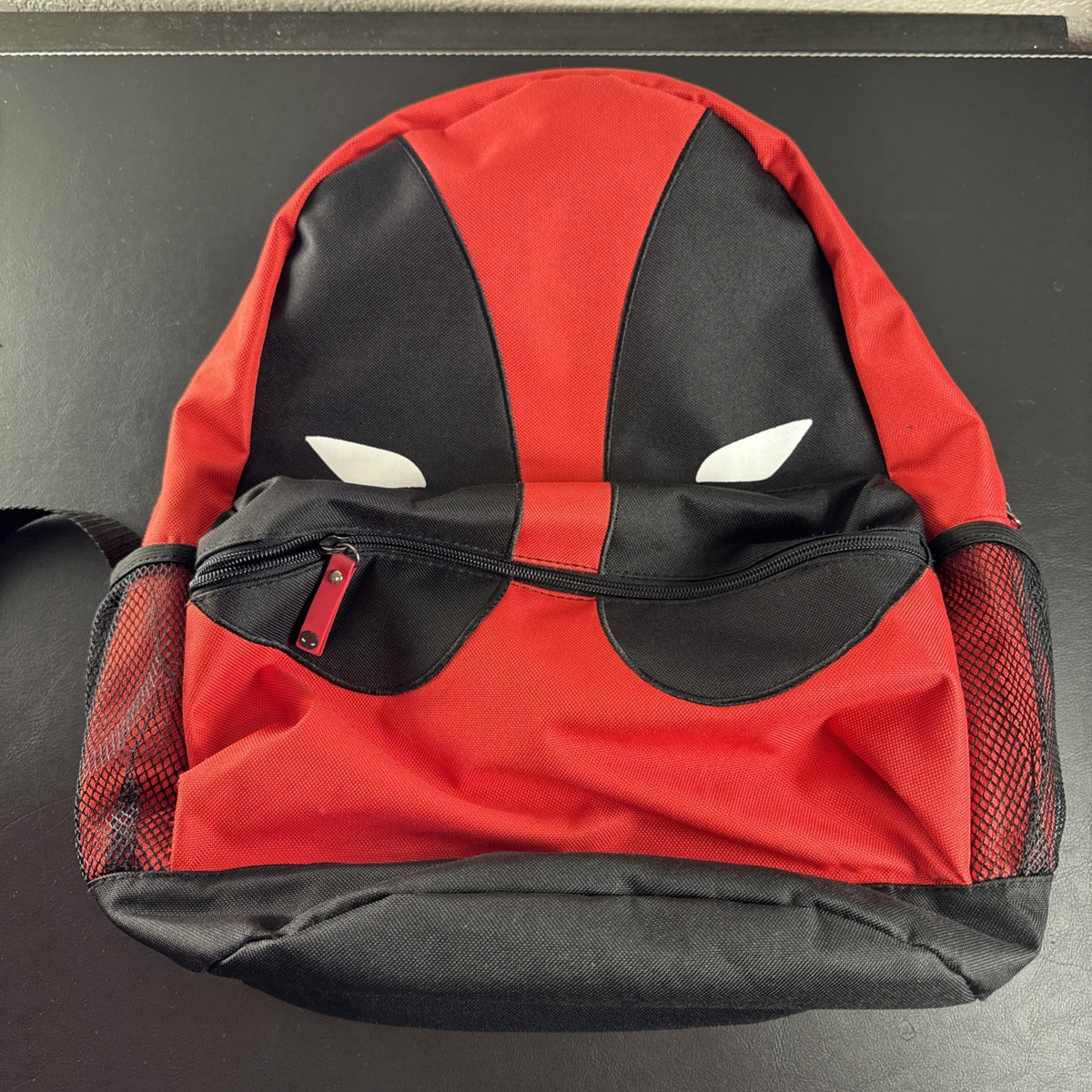 Official Marvel Deadpool red and black character backpack featuring the iconic eye mask design.