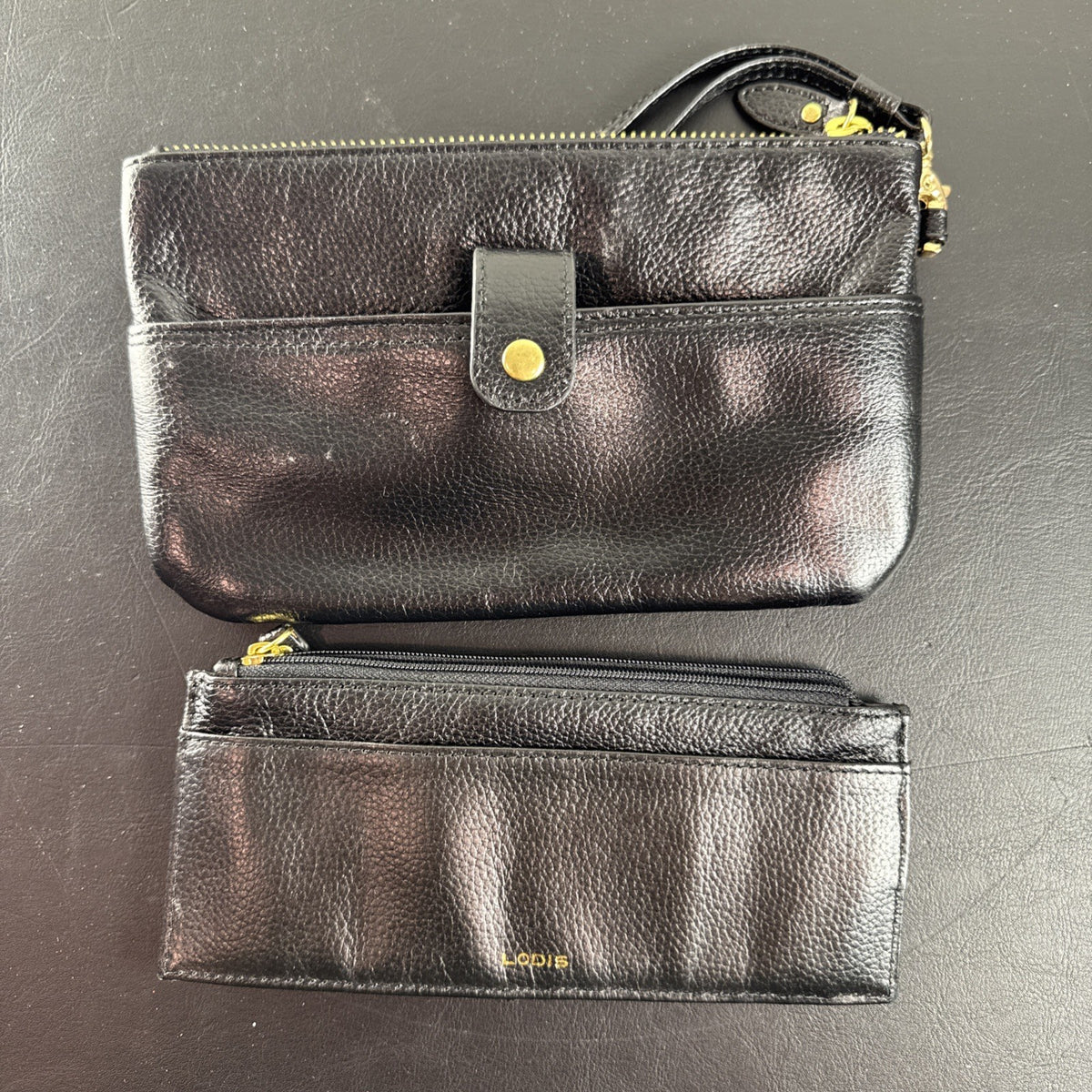 LODIS black pebbled leather wristlet clutch and matching card wallet set with gold-tone hardware.