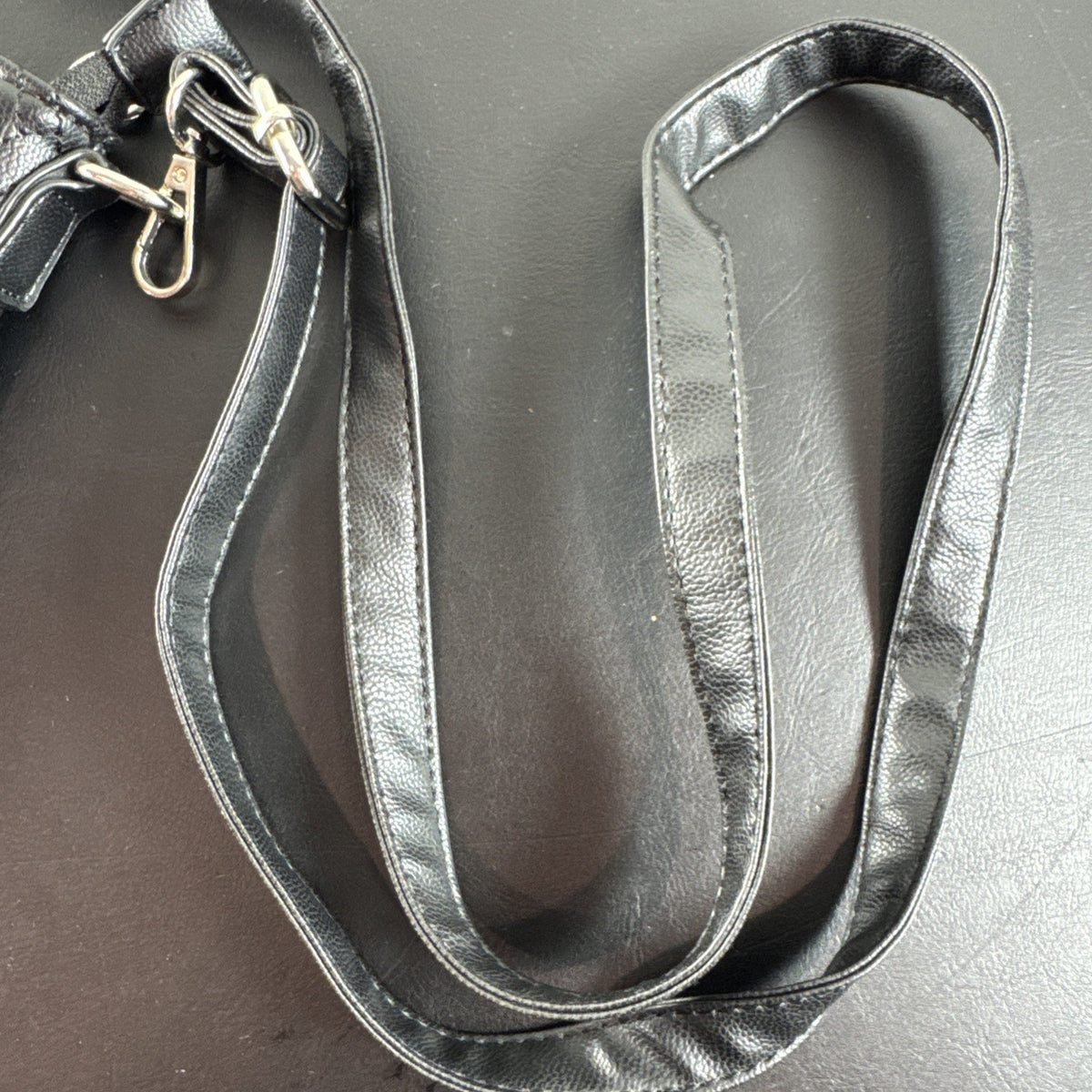 Bella Russo black quilted faux leather crossbody bag with silver-tone heart zipper pull.