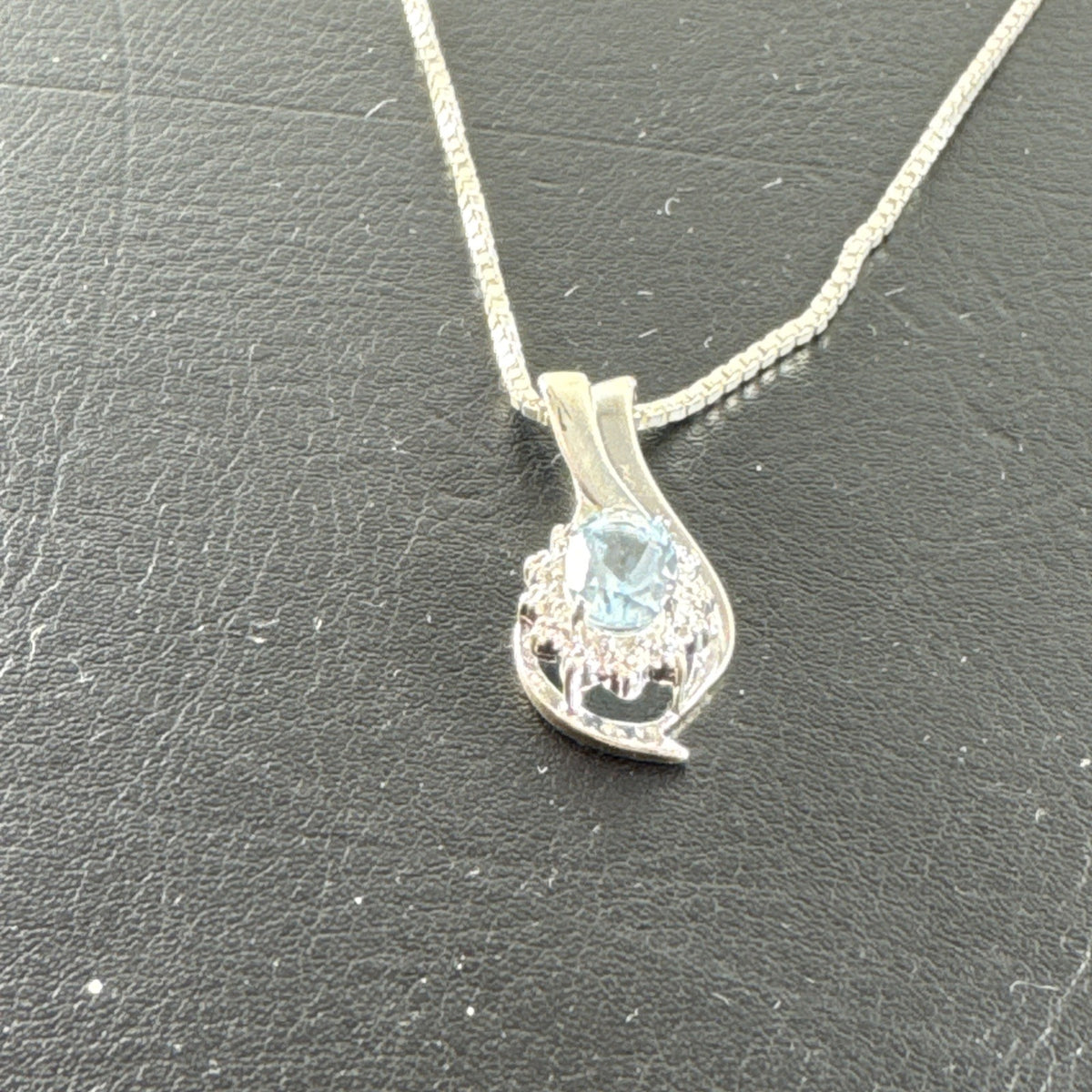 Solid 925 sterling silver teardrop swirl pendant with a light blue oval stone on an Italian box chain.