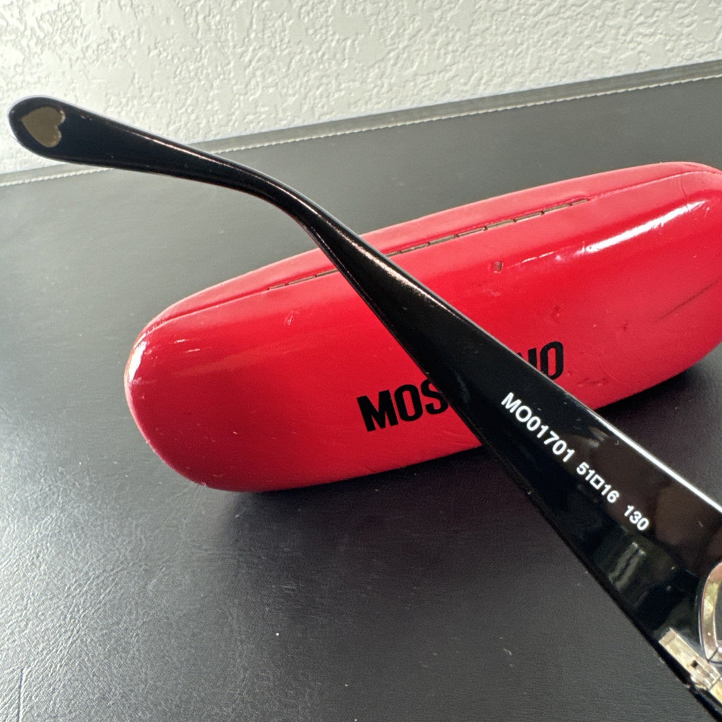 Vintage Moschino MO01701 black acetate eyeglass frames with rhinestone heart cutouts on temple arms.