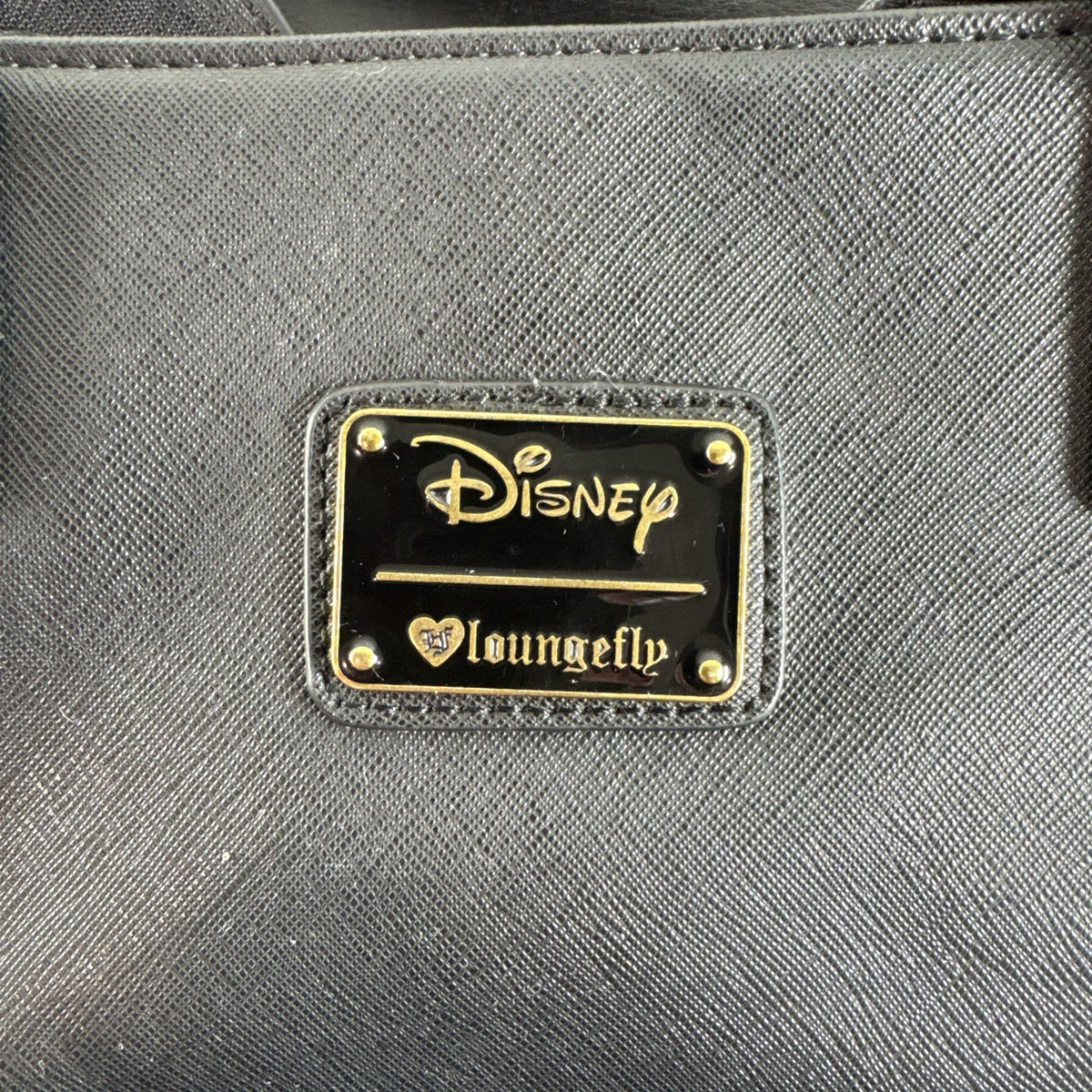 Loungefly Disney Hocus Pocus Thackery Binx black faux leather tote bag showing die-cut cat ears and green eyes.