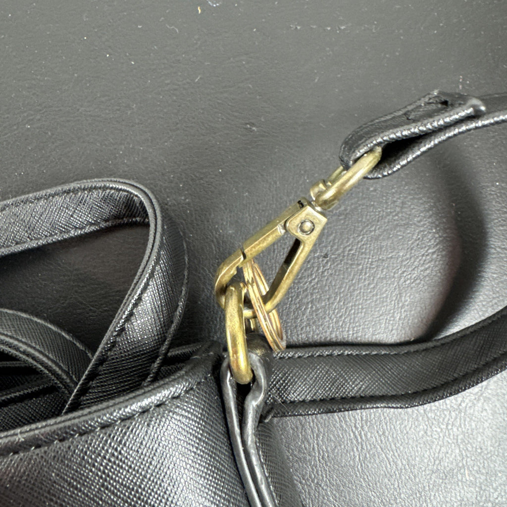 Loungefly Disney Hocus Pocus Thackery Binx black faux leather tote bag showing die-cut cat ears and green eyes.