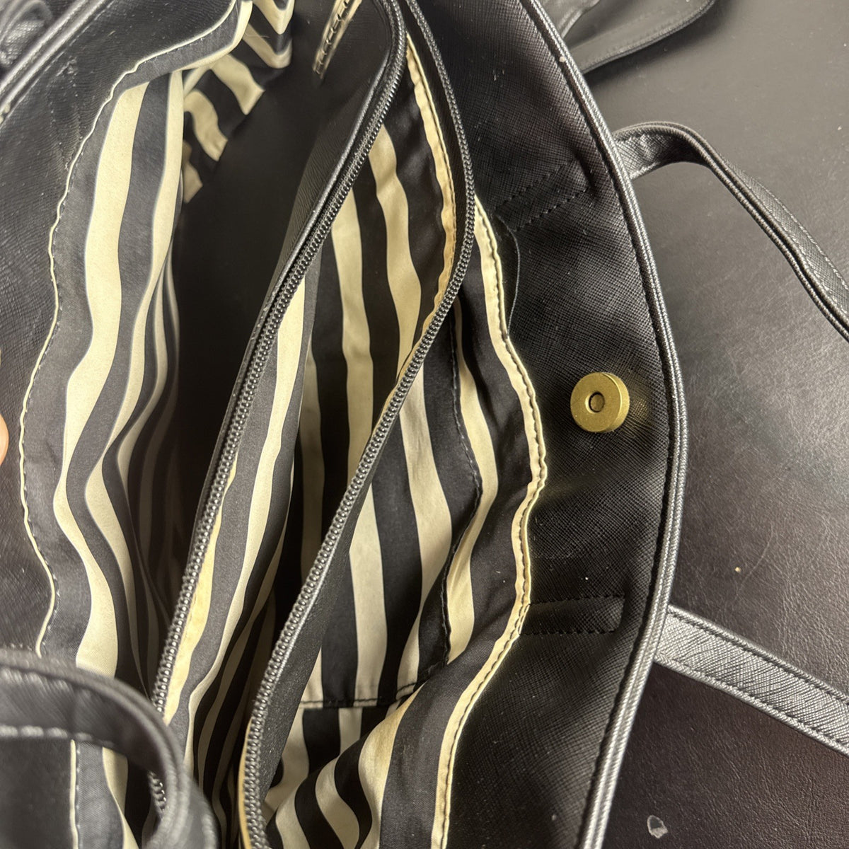 Loungefly Disney Hocus Pocus Thackery Binx black faux leather tote bag showing die-cut cat ears and green eyes.