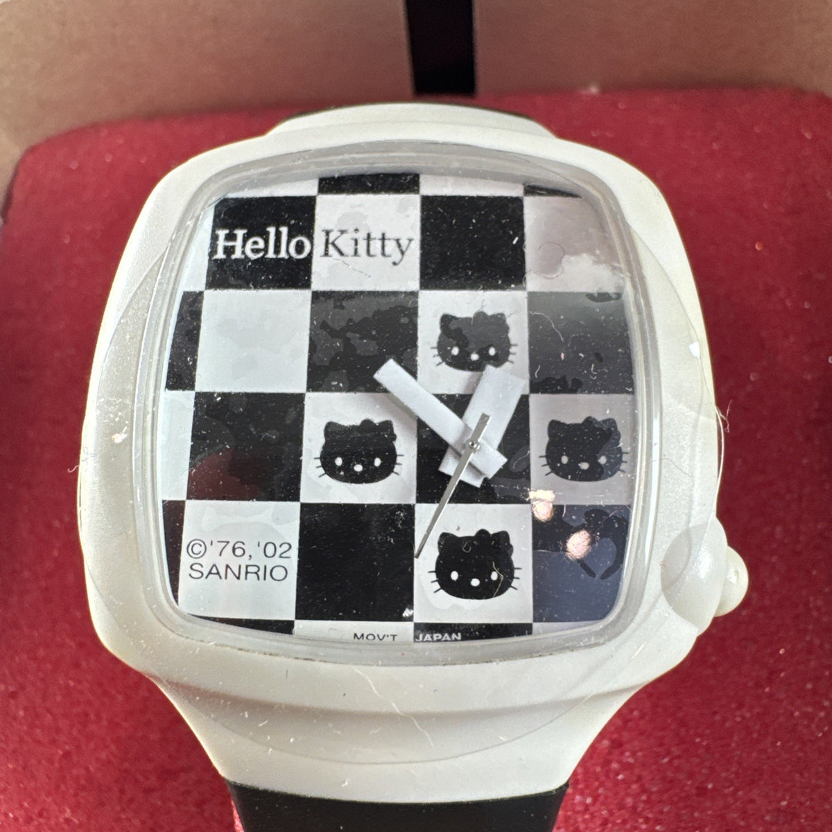2002 Sanrio Hello Kitty watch with black and white checkerboard face, original zippered case, and tags.