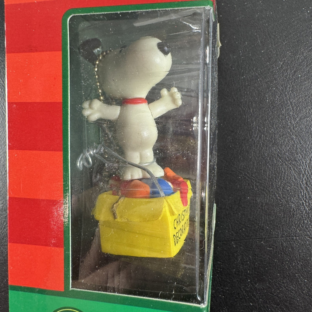 Forever Fun Peanuts Snoopy clip-on holiday ornament holding a Christmas decorations box in original packaging.