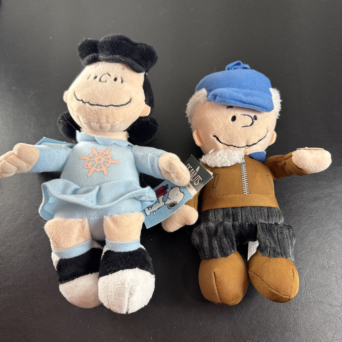 Peanuts 10-inch musical holiday plush figures set featuring Charlie Brown and Lucy in winter outfits