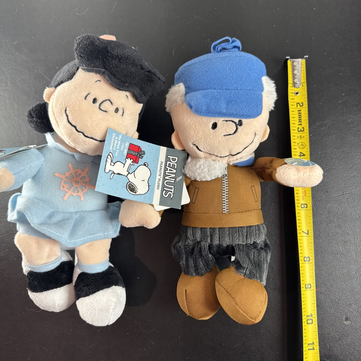 Peanuts 10-inch musical holiday plush figures set featuring Charlie Brown and Lucy in winter outfits