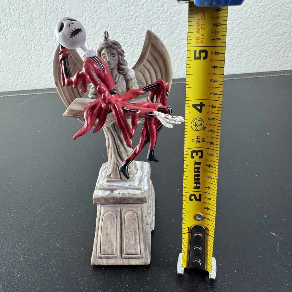 Hallmark Keepsake Jack Skellington musical Christmas ornament draped over cemetery angel