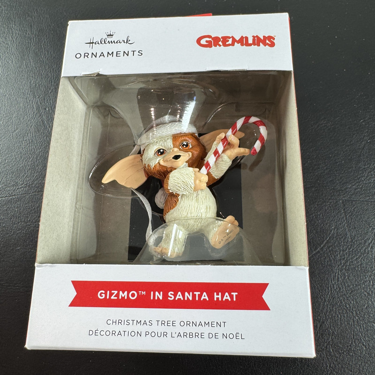 Hallmark 2024 Gremlins Gizmo resin Christmas ornament wearing a Santa hat and holding a candy cane in original packaging.