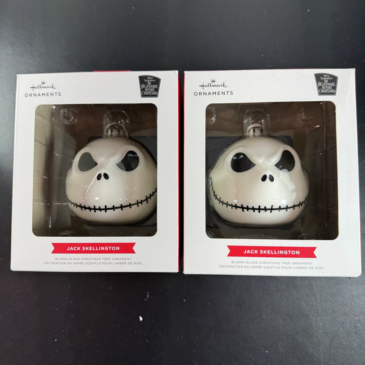 Set of two Hallmark Jack Skellington white blown glass Christmas ornaments in original packaging.