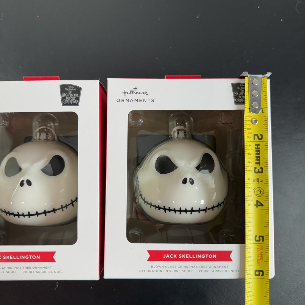 Set of two Hallmark Jack Skellington white blown glass Christmas ornaments in original packaging.