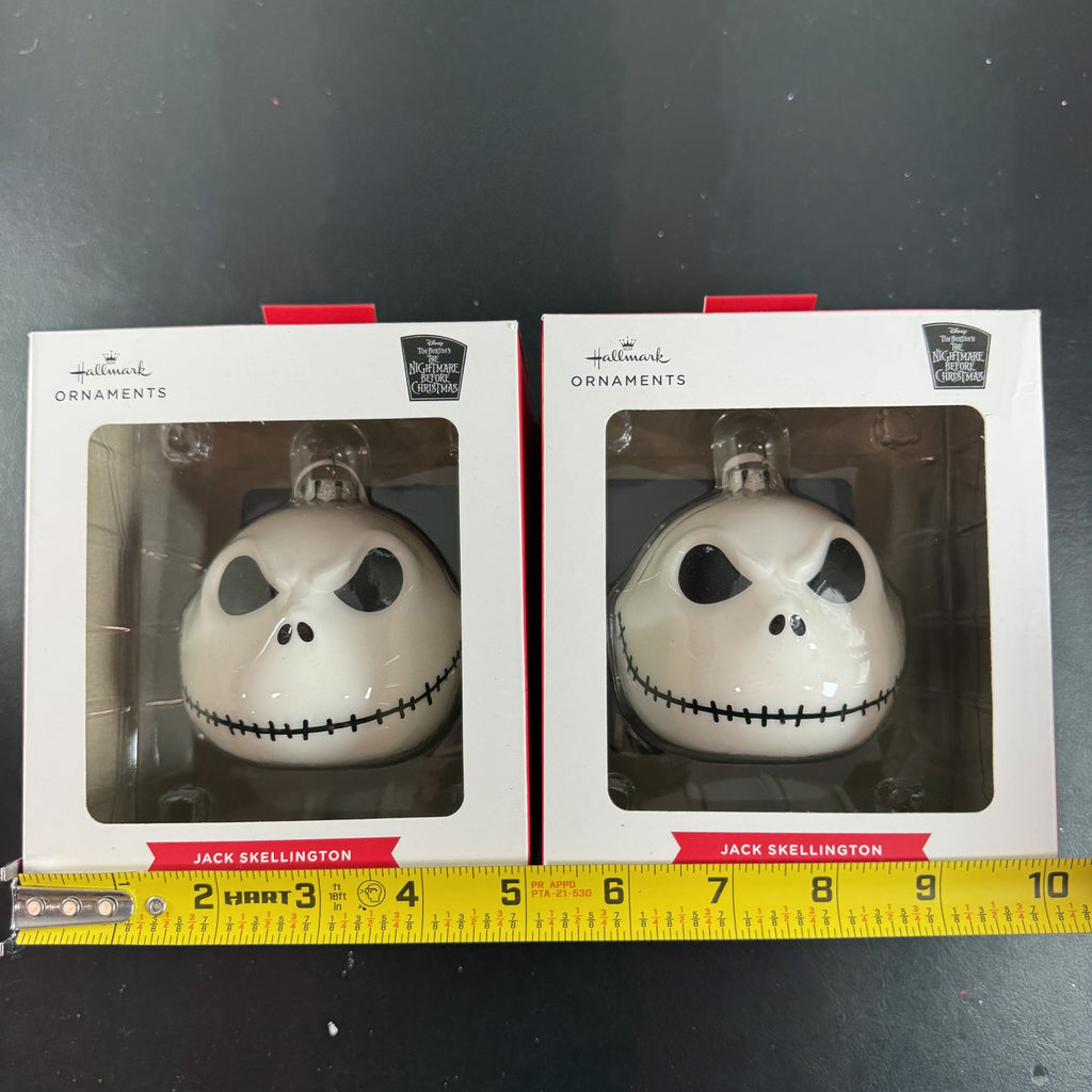 Set of two Hallmark Jack Skellington white blown glass Christmas ornaments in original packaging.