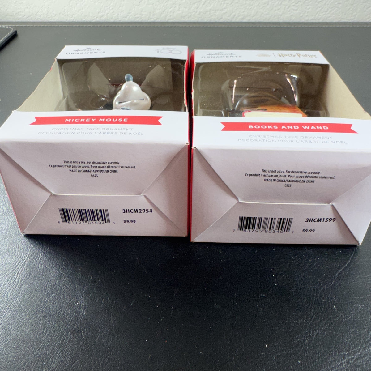 Set of 2 Hallmark ornaments featuring Disney 100 silver glitter Mickey Mouse and Harry Potter Hogwarts books in original boxes