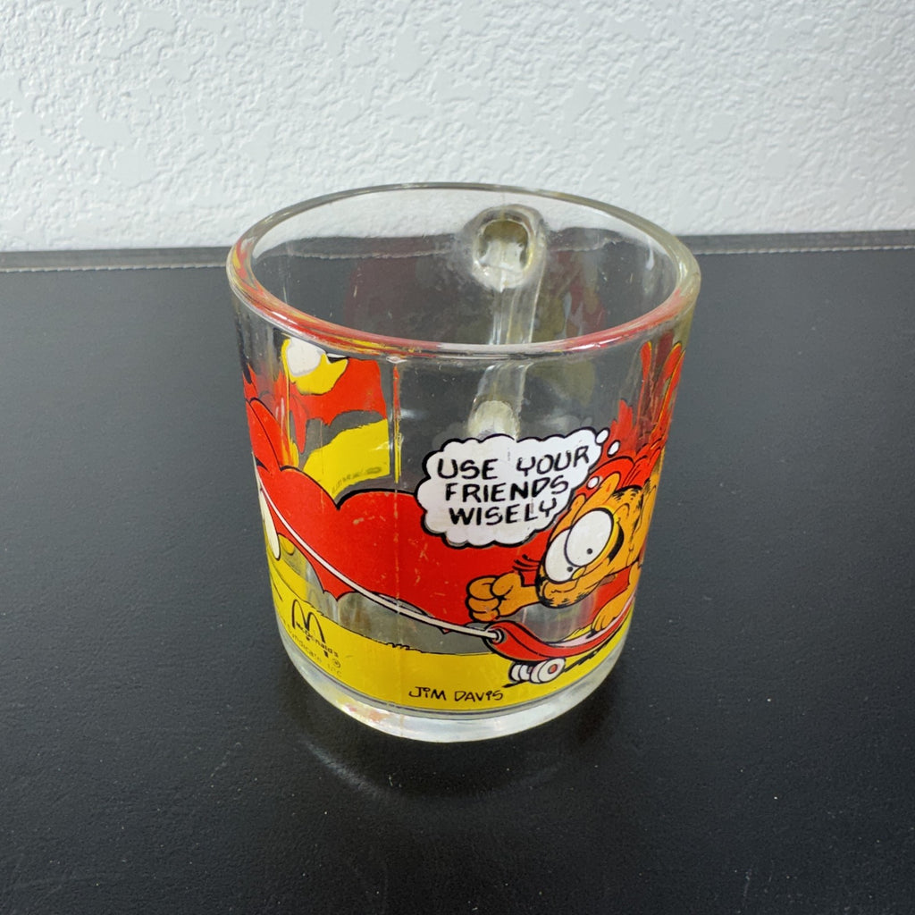 Vintage 1978 McDonald's clear glass mug featuring Garfield on a skateboard pulled by Odie.