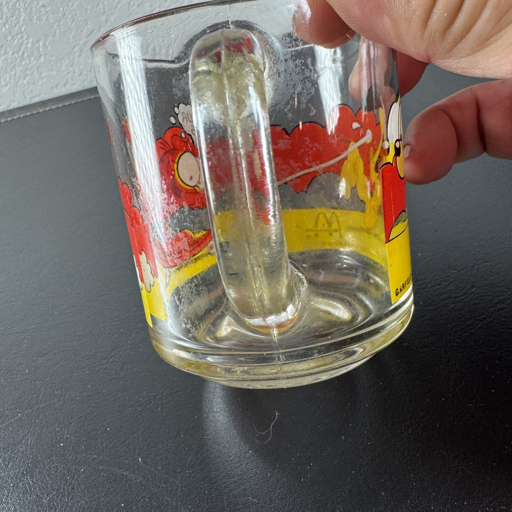 Vintage 1978 McDonald's clear glass mug featuring Garfield on a skateboard pulled by Odie.