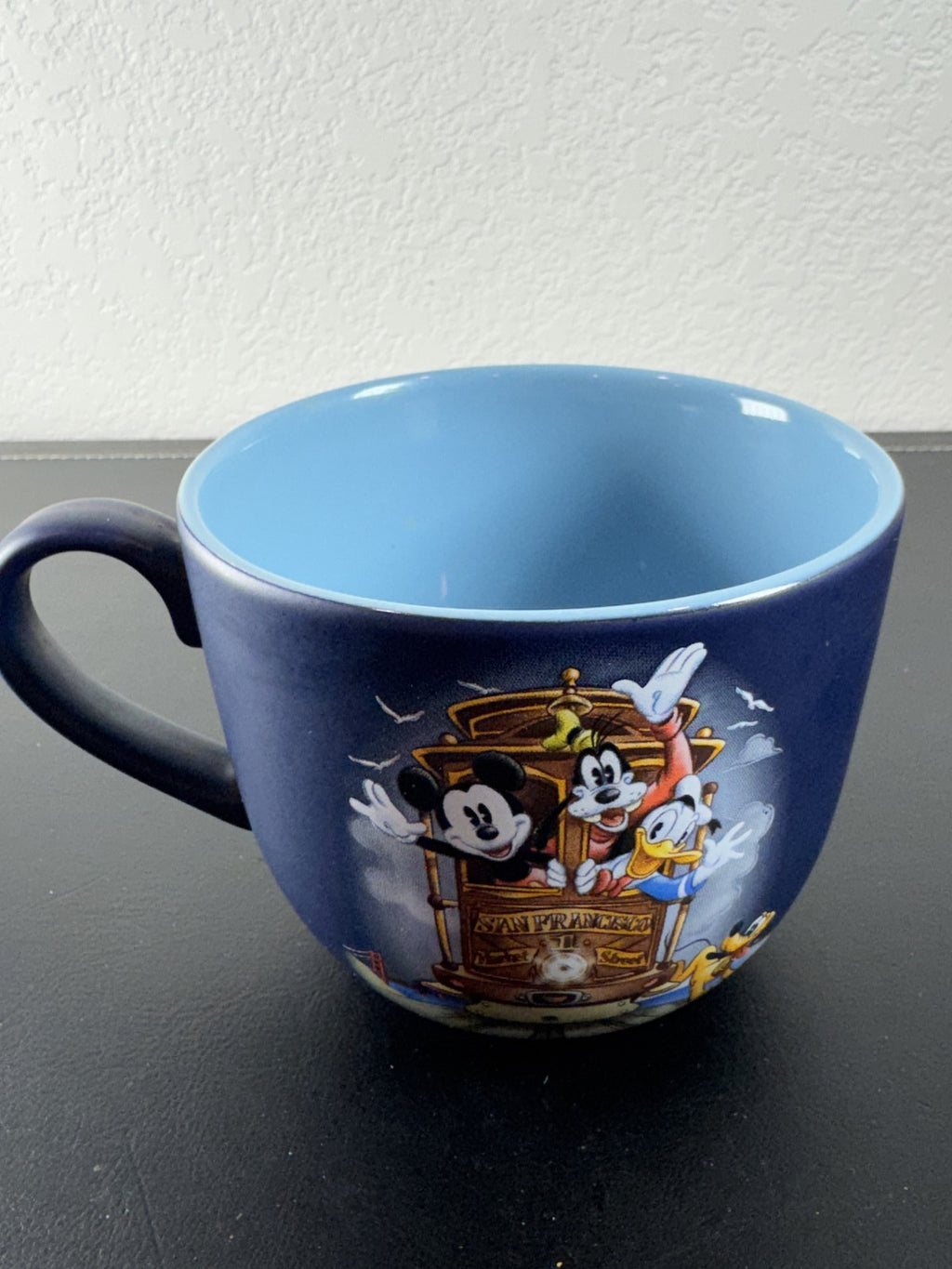 Disney navy blue ceramic mug featuring Mickey Mouse and friends riding a San Francisco cable car