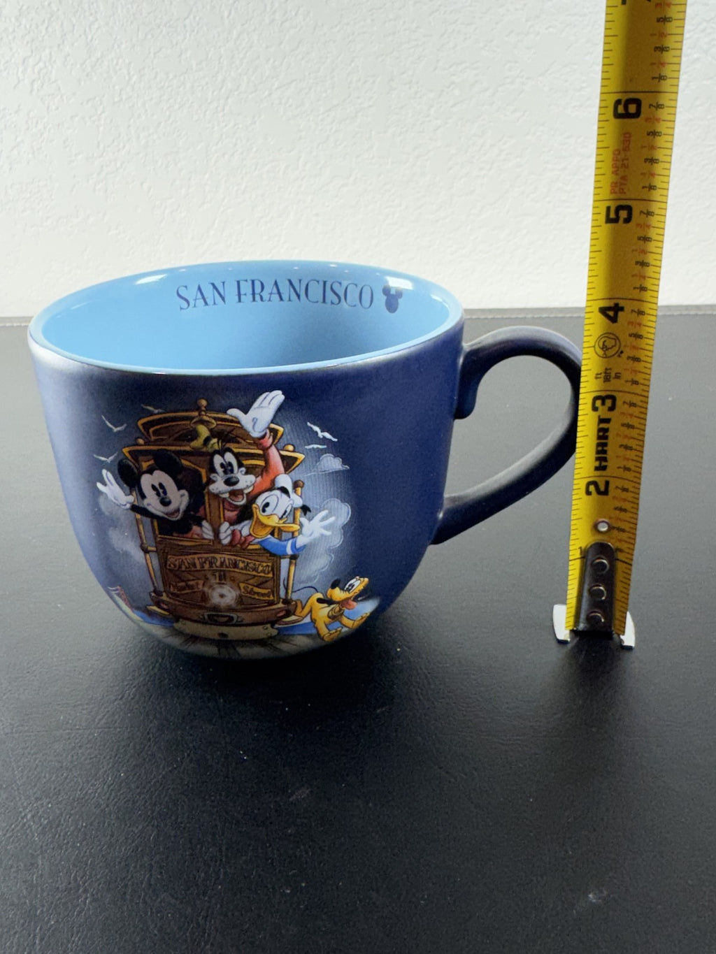 Disney navy blue ceramic mug featuring Mickey Mouse and friends riding a San Francisco cable car