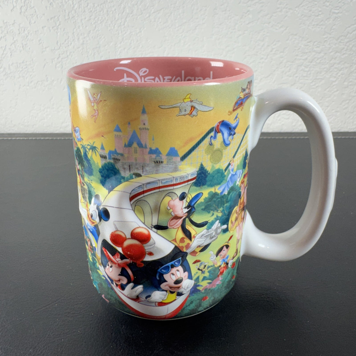 Disneyland park map ceramic coffee mug featuring Mickey Mouse and a pink interior glaze.