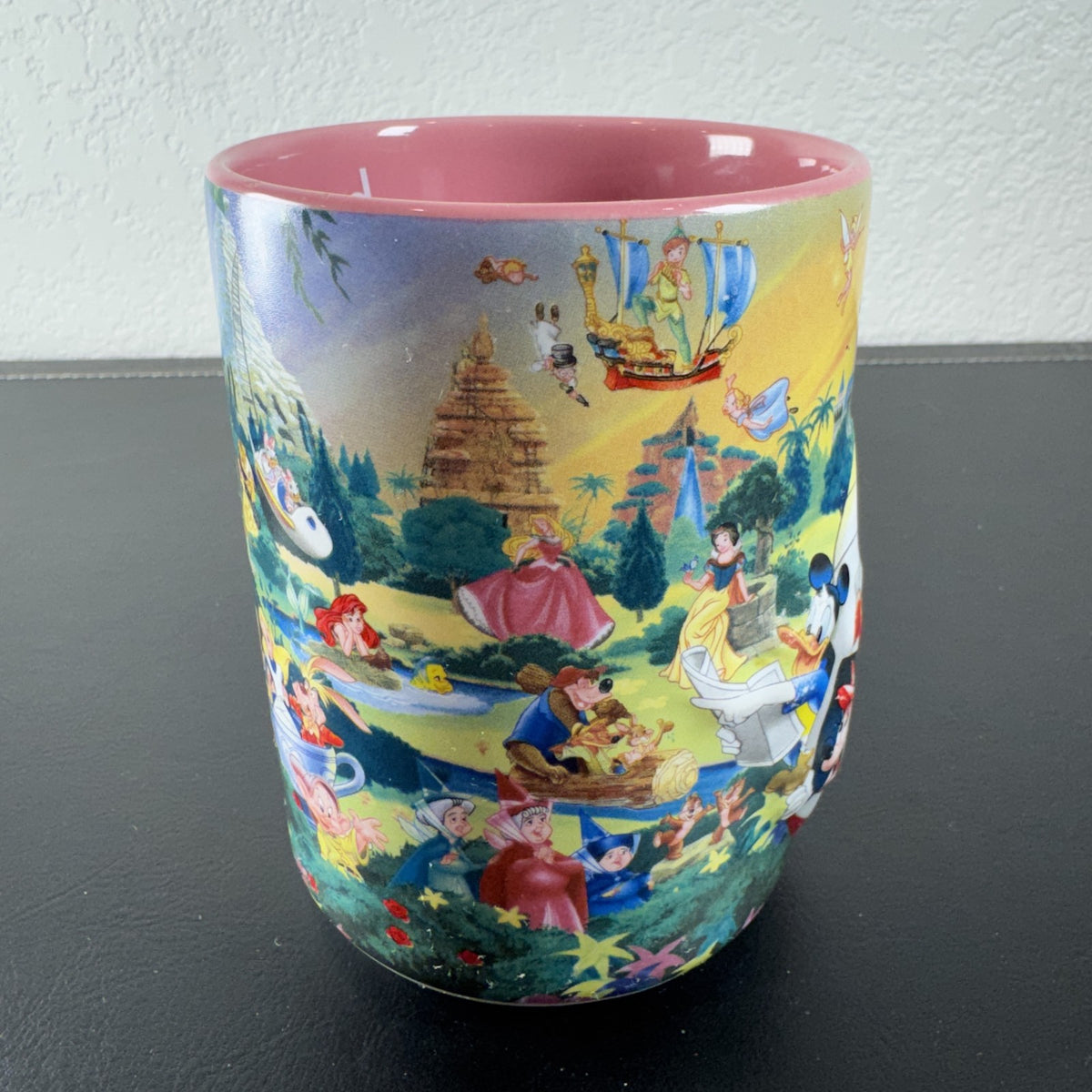 Disneyland park map ceramic coffee mug featuring Mickey Mouse and a pink interior glaze.