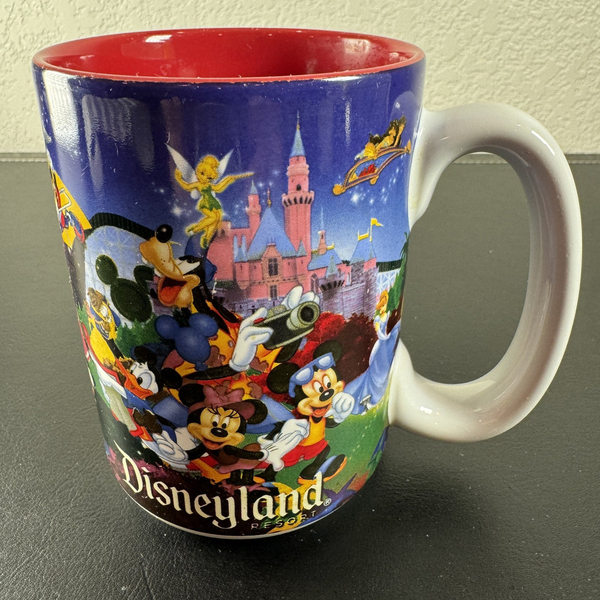 Disneyland Resort ceramic coffee mug with wrap around Disney character collage and bright red interior finish