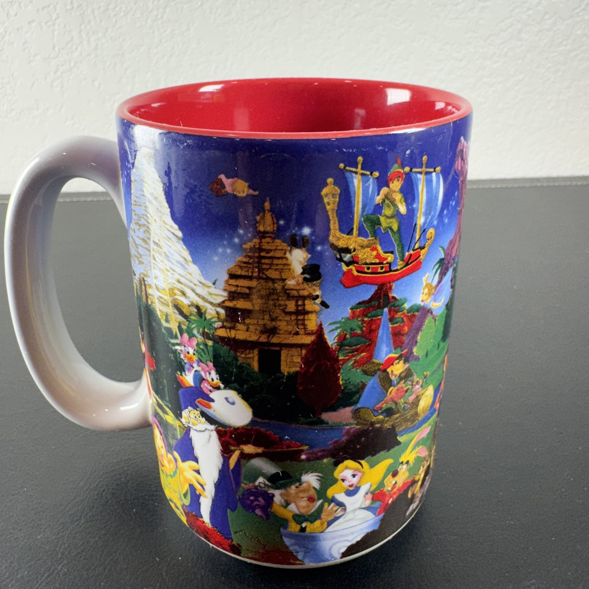 Disneyland Resort ceramic coffee mug with wrap around Disney character collage and bright red interior finish