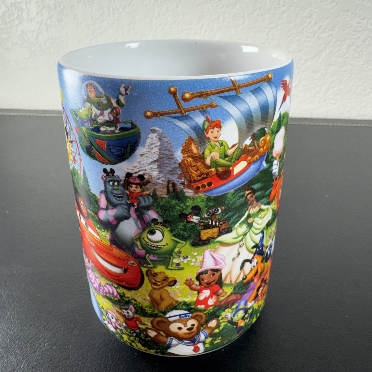 Disney Parks Grandma ceramic mug with Mickey Mouse, Sleeping Beauty Castle, and classic characters wraparound graphic.