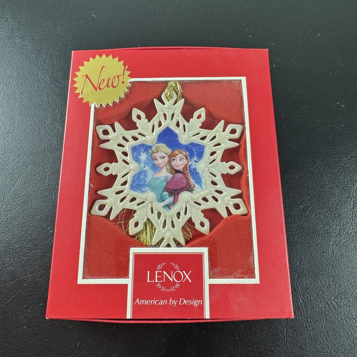 Lenox Disney Showcase Frozen Elsa and Anna fine porcelain snowflake Christmas ornament with gold tassel.