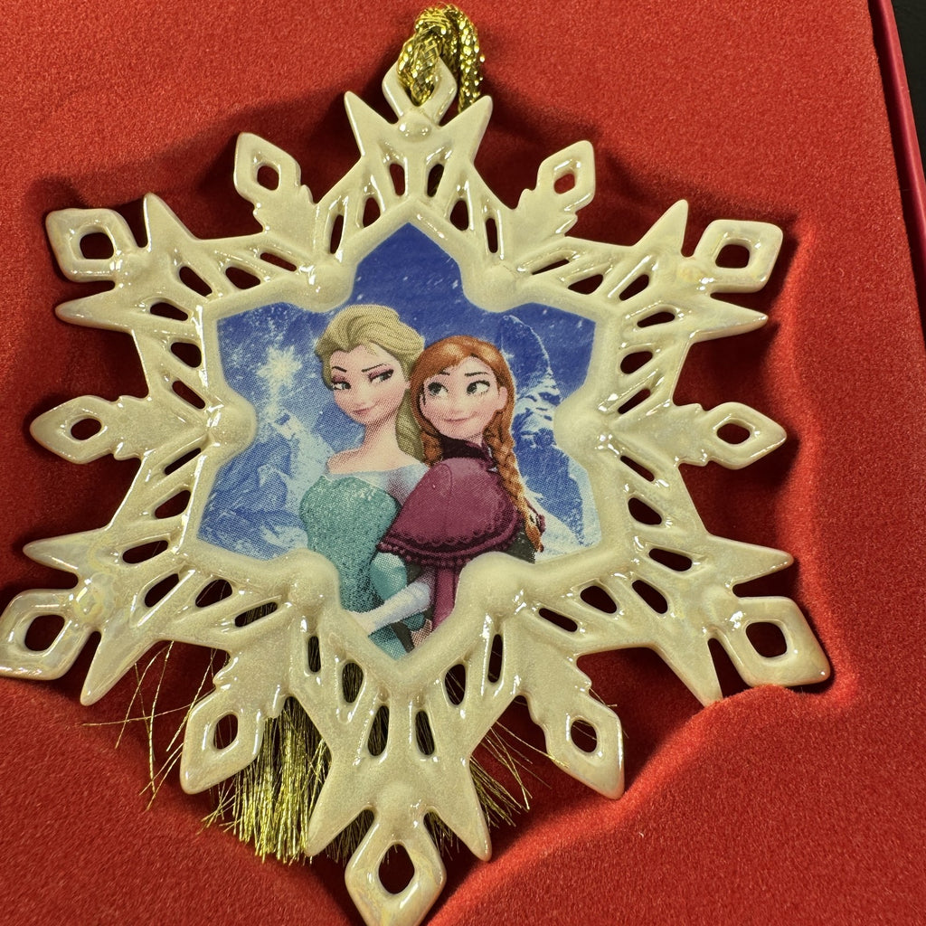 Lenox Disney Showcase Frozen Elsa and Anna fine porcelain snowflake Christmas ornament with gold tassel.